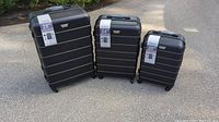Full set of three black textured Coolife suitcases in 28", 24", and 20" sizes arranged outdoors showing front view and size labels.