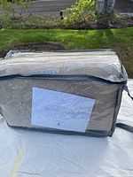 Rug pad in clear plastic packaging showing beige textured material.