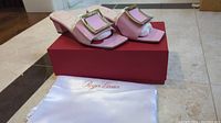 Pink Roger Vivier heels displayed on their red box alongside the white dust bag with Roger Vivier logo.