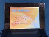 Photo showing digital photo frame displaying key features including slideshow, audio background or solo, video playback, and audio slideshow.
