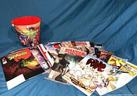 Photo showing pile of assorted 2019 Comic Book Day comics along with Avengers metal bucket