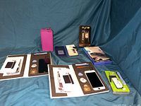Overview of all items laid out on cloth, showing repair kits, phone cases, and charger in original packaging.