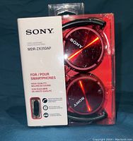 Front of unopened Sony MDR-ZX310AP headphones package showing red headphones and product name