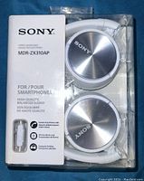 Front view of the new boxed Sony MDR-ZX310AP white stereo headphones showing product and branding details.