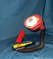 Red Snake Light and yellow LED flashlight with flexible necks on blue background showing design and condition.