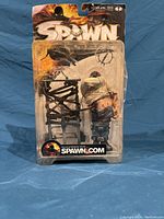 Front view of Spawn Clown figure in unopened blister pack showing figure and chair accessory