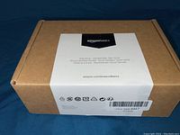 Closed box with AmazonBasics branding and barcode, cardboard packaging with label describing door knob set