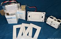 Two dimmable switches, one outlet with USB ports, three white cover plates, and instruction manuals shown on blue background.