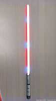 Full view of the lightsaber with red and blue light effects lit up