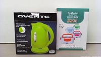 Photo showing the boxed Ovente electric kettle and the box of the Reabulun electric lunchbox side by side.