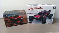 Photo showing boxed DEERC DE67 remote control car and Polar Toys 1/8 scale monster truck boxes side by side.