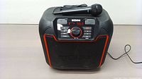 Front view of black ION Sport portable speaker with microphone laid on top. Controls and digital display visible on top section.