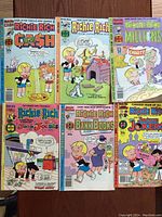 Photo showing six Richie Rich comic books laid out side by side, each with distinct colorful covers and titles.