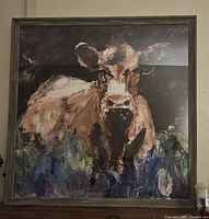 Front view of framed cow print artwork showing the full image and frame.
