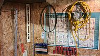 Wide shot of tools mounted and arranged on wall including screwdrivers, level, yardsticks, and hex keys