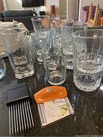 Glassware and kitchen tools together showing variety of glasses and utensils on counter.