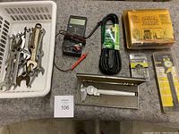 Photo showing the basket with multiple wrenches, trickle charger, block heater cord, forearm forklift box, dial caliper in packaging, vintage caliper in metal case, and cotter/hitch clips package.