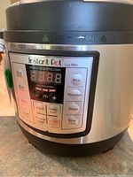 Front view of Instant Pot Lux Mini digital control panel with cooking options and display.