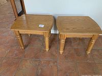 Two solid oak side tables showing their full form, finish, and condition from the front view.