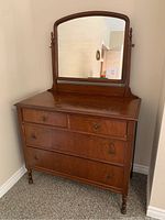 Full front view of the vintage wooden dresser with mirror, showing wood finish, drawer arrangement, and swivel mirror attached.