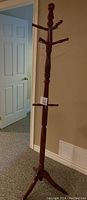 Full view of wooden coat rack showing entire height and peg arrangement