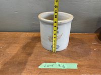 Height measurement of the crock using a measuring tape indicating approximately 9.5 inches tall.