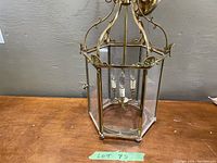 Front view of hexagonal brass and glass hanging lantern showing overall design