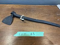 Full length view of the antique blacksmith housing iron showing the long handle and broad flat blade with tags attached.