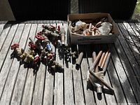 Photo showing several copper valve fittings with red handles and some pipe sections on a wooden surface.