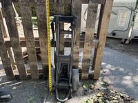 Front view of black foldable golf pull cart with two wheels, labeled 'Intrepid', measuring about 33 inches high.