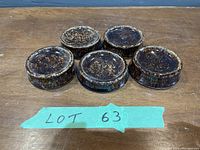 Top view of 5 handmade pottery lifts with dark mottled brown glaze on table surface