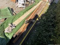 Full length antique railway rail covered partially by tarp, showing its length and industrial nature.