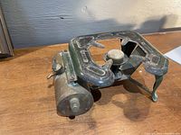 Full view of the vintage single-burner stove showing burner assembly and brass fuel tank on the left.