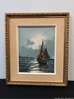 Frontal view of the framed oil painting showing sailing boats on water with a cloud-filled sky and the signature at bottom right.