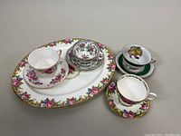 Photo showing the Paragon Tapestry Rose 14-inch serving platter and three teacup and saucer sets arranged on a table.