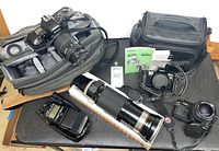 Overview of all cameras, lenses, flash and cases on black table