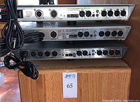 Rear panels of three stacked units showing balanced XLR I/O, RJ45 port, model labeling and IEC power cords