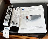 Remote control, bag of replacement feet and screws, and owner’s manual on top of unit