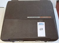 Closed view of dark brown hard plastic carrying case with metal clasps and a label stating 'Sterling Cartridge'.