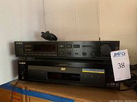 Front view of Sony SDP-505ES digital surround processor stacked on Sony DVP-S7700 DVD/CD/Video CD player showing power cables and front panels.