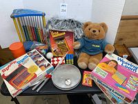 All items shown together including abacus, Speak & Spell, Little Professor, AG Bear, Rubik's cube, weaving loom, and other toys.
