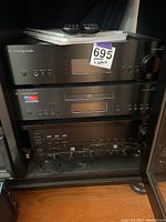 Three black Cambridge Audio stereo components stacked in a cabinet
