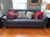 Front view of dark grey couch with multiple throw pillows