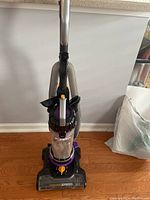 Front view of the Eureka Power Speed vacuum showing clear dust canister, hose, and base.