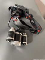 Top angled view of black LED headlamp showing three LED light units and adjustable elastic strap with LED print.