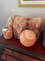 Collection of six Himalayan salt lamps, including large rough cut blocks, ball shaped, and lotus carved lamp.