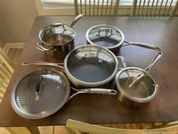 Overhead view of Rorence pot, Zwilling sauté pan, saucepans and grill pan with lids on table