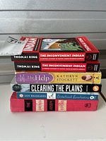 Stack of six books showing their spines and covers to identify titles and authors.