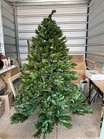 Photo of the assembled artificial Christmas tree showing the green pine needles and overall shape.