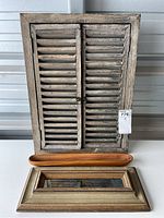 Photo showing all four items: wooden shuttered mirror with metal knobs, two vintage narrow rectangular mirrors with large frames, and the wood olive tray placed between the shutters mirror and the large framed mirrors.